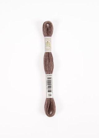 A skein of embroidery floss in a muted taupe-brown color, wrapped with a white paper label that reads 'ECO VITA' and shows the number '104' at the bottom, set against a plain white background.